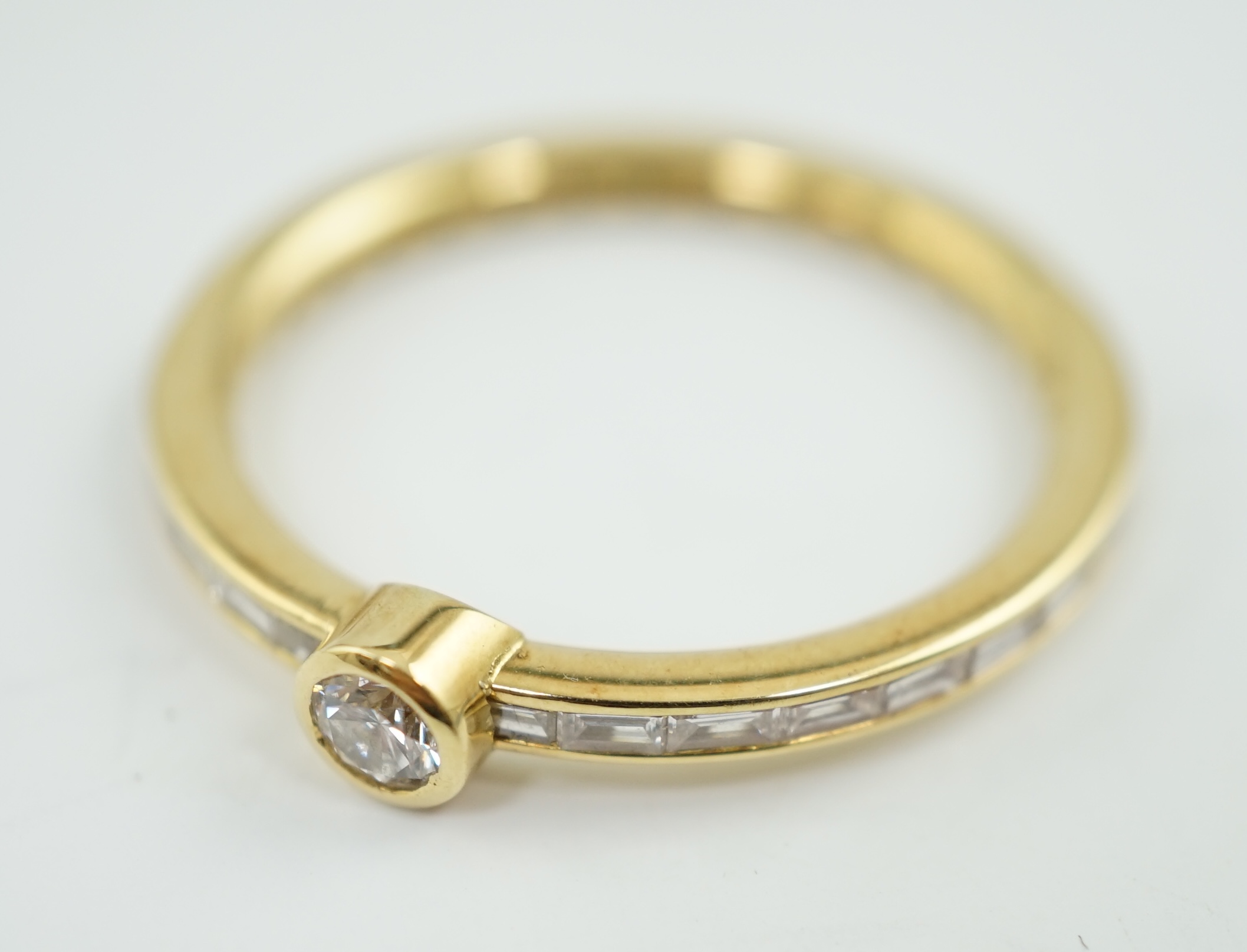 A modern 18ct gold, round and baguette cut diamond set ring